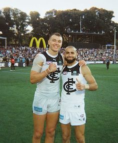 two men standing next to each other on a field