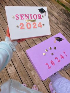 a person holding a sign that says senior year on it and some other items in front of them