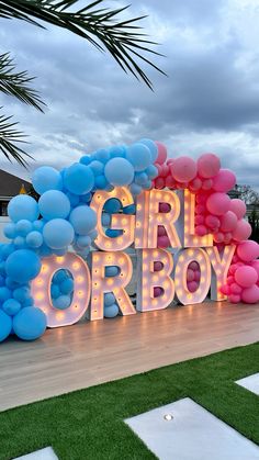 a sign that says girl or boy with balloons in the shape of letters on it