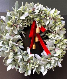 a christmas wreath with bells and greenery