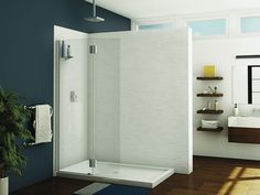 a white bathroom with blue walls and wood flooring is pictured in this image, there is a shower stall that has the door open