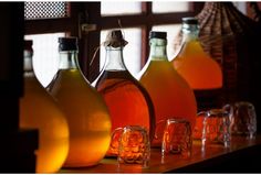 several bottles of liquid are lined up on a shelf