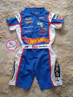 a blue and white racing suit laying on top of a rug