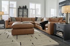 a living room with a large sectional couch and two lamps on either side of the couch