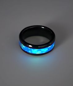 Custom made black ceramic ring.  Inlaid with the highest quality ultra violet reactive glow powder and glow glitter.  Comes in a black velvet gift box with a UV keychain light. Band is 8mm wide, available in multiple sizes Perfect for wedding bands, Valentine's day gifts, birthdays, Christmas, or any occasion. Personalize with free engraving inside the band Engraving available in a variety of fonts.  See third picture for font selection Find more selections in my shop: essentialjewels2022.etsy.c Luminous Ring Jewelry For Gifts, Luminous Ring Jewelry As A Gift, Black Glow In The Dark Jewelry For Parties, Black Glow In The Dark Party Jewelry, Magical Luminous Blue Jewelry, Magical Black Jewelry For Gifts, Blue Luminous Jewelry For Party, Luminous Blue Jewelry For Parties, Glow In The Dark Black Jewelry For Gift