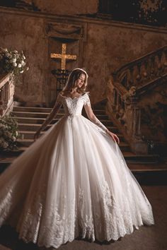 a woman in a wedding dress standing on some stairs