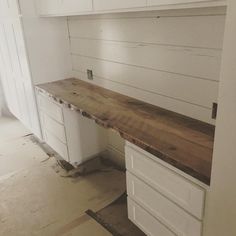 an unfinished kitchen counter with white cabinets and drawers in the back ground, under construction