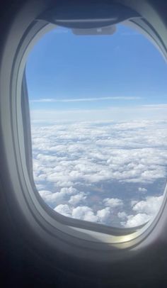 an airplane window looking out at the clouds