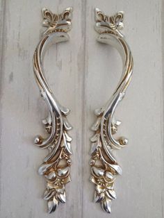 two metal handles with flowers and leaves on the side of a door, both in gold or silver