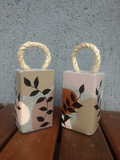 two small bags sitting on top of a wooden table next to each other with rope handles