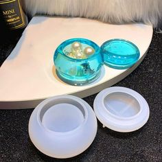 two bowls are sitting on a table next to a bottle and some other items in front of it