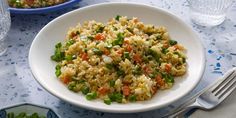 a white plate topped with rice and veggies on top of a blue table cloth