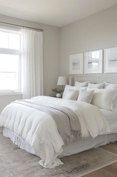 a white bed sitting in a bedroom next to a window