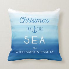 a blue and white pillow that says christmas by the sea