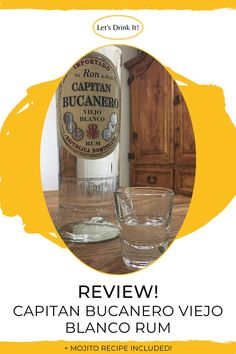 a bottle of captain bucanero viejo and two glasses on a wooden table