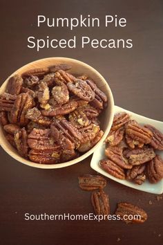 a bowl filled with pecans sitting on top of a table next to another bowl full of pecans