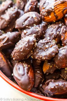 a bowl filled with chocolate covered almonds and sprinkled with sea salt on top