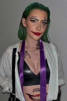 a woman with green hair and makeup is wearing a purple belted corset