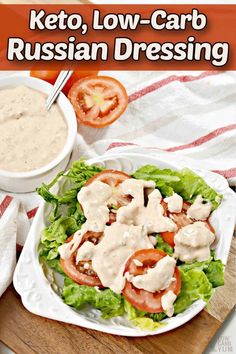 a white plate topped with salad and dressing next to a bowl of ranch dressing on top of a wooden cutting board