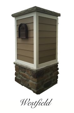 a brown and white mailbox sitting on top of a brick wall with the words westfield above it