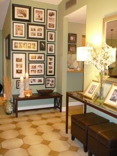 a living room filled with furniture and framed pictures on the wall above a coffee table