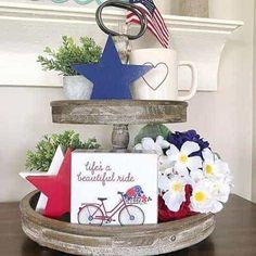 a wooden tray with flowers and patriotic decorations on it, along with a sign that says life's a beautiful ride