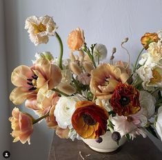 a vase filled with lots of different colored flowers