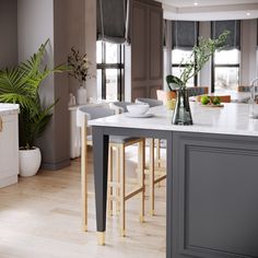 a kitchen island with stools in front of it and plants on the counter top