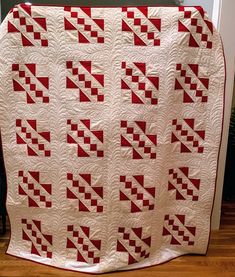 a red and white quilt is on the floor