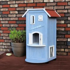 a blue dog house next to a brick wall