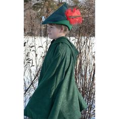 a young boy wearing a green coat and red hat