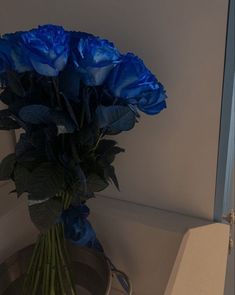 a bouquet of blue flowers sitting on top of a table next to a white box