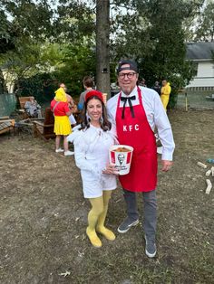 a man and woman dressed up in costumes standing next to each other holding buckets