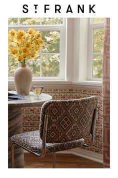 a chair sitting next to a vase with yellow flowers in it and the words st frank