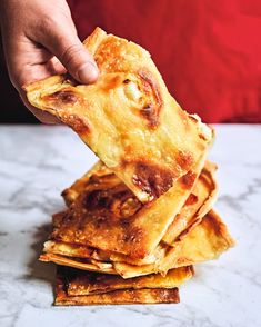 a person reaching for some food on top of a table next to a pile of crackers