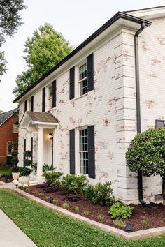 a white brick house with black shutters