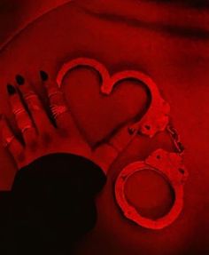 a pair of handcuffs, ring and lipstick are on the ground in front of a red light