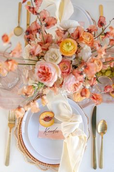 the table is set with flowers and place settings