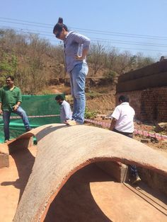 three people standing on top of a cement structure