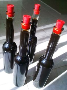 four black bottles with red caps are sitting on the floor