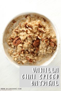 a white bowl filled with oatmeal and nuts on top of a table