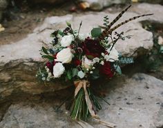 a bridal bouquet sitting on some rocks