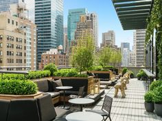 an outdoor patio with tables, chairs and potted plants on the roof of a building