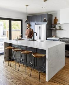 a kitchen with an island and stools in it