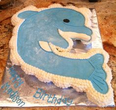 a birthday cake that is shaped like a dolphin