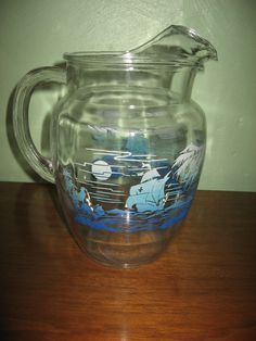 a glass pitcher sitting on top of a wooden table