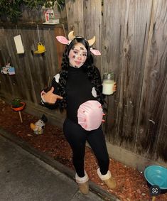 a woman dressed as a cowgirl holding a glass of milk and giving the thumbs up