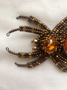 "Buy the Spider jewelry as unique Halloween brooch. Spider pin has a has a size approximately 2*3 inches (5*7,5 cm). This Beaded insect brooch is the best Halloween gift. A Spider jewelry brooch is carefully bead embroidered on leather using Czech crystals, seed beads. The central element can be made of imitation of amber, other gemstone or crystal to your order. * Size gold insect brooch: approx. 2*3 inches (5*7,5 cm) with a sweep of all his paws * Color customization for custom orders is avail Handmade Brooches For Halloween Gift, Halloween Brooch, Spider Brooch, Spider Crafts, Insect Brooch, Spider Jewelry, White Cocktails, Jewelry Halloween, Jewelry Brooch