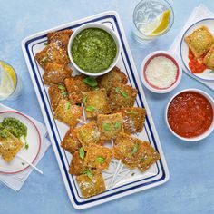 an assortment of appetizers with sauces and condiments on the side