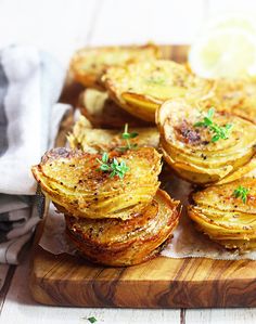 some food is sitting on a cutting board and ready to be eaten with lemon wedges